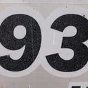 Ninety three in bold black vinyl digits sprayed a mist of fine white paint flecks.